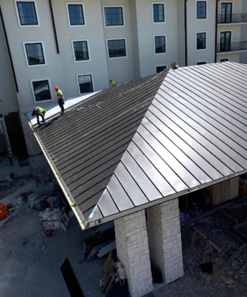 Crew installing standing seam metal roof panels on a commercial project in Duluth